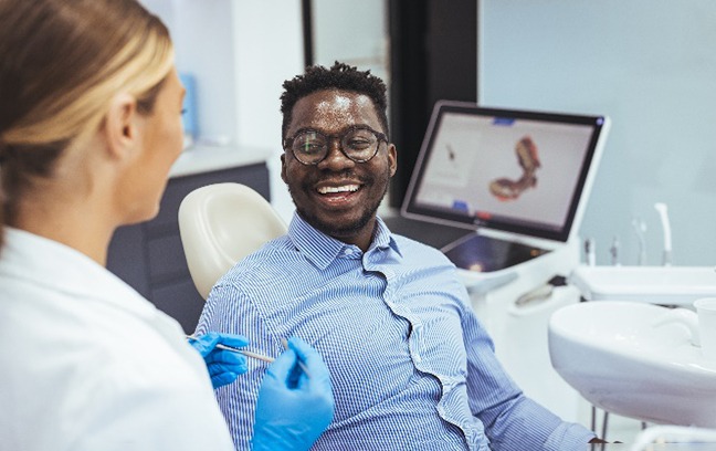 Man smiling while talking to dentist at consultation