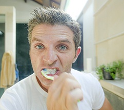 Man with dental implants in Spring Hill brushing his teeth