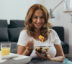 Woman with dental implants in Spring Hill eating a fruit salad