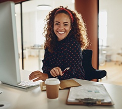 Woman with dental implants smiling at an office