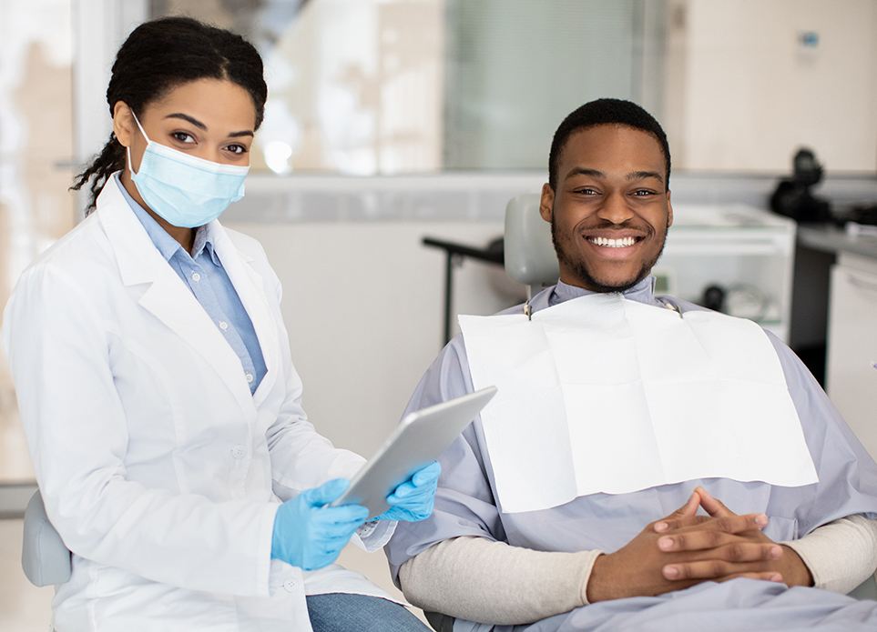 Dentist and male patient smiling during checkup