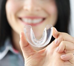 a person holding custom mouthguards to protect dental implants