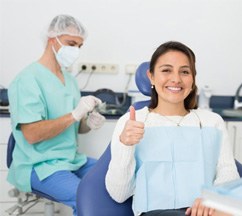 a patient giving a thumbs up after getting dental implants