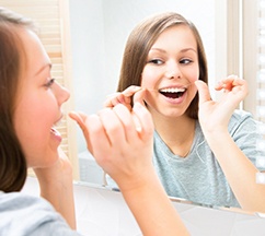 Woman flossing her teeth