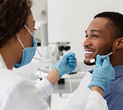 Dentist and patient smiling at each other during dental checkup