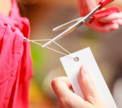 Person using scissors to remove clothing tag
