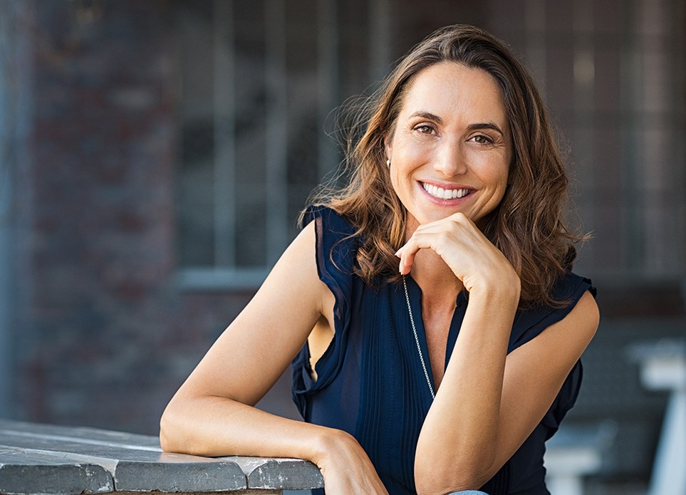 Woman smiling while sitting at table outside