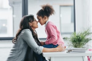 parent touching their nose to their child sitting on a counter