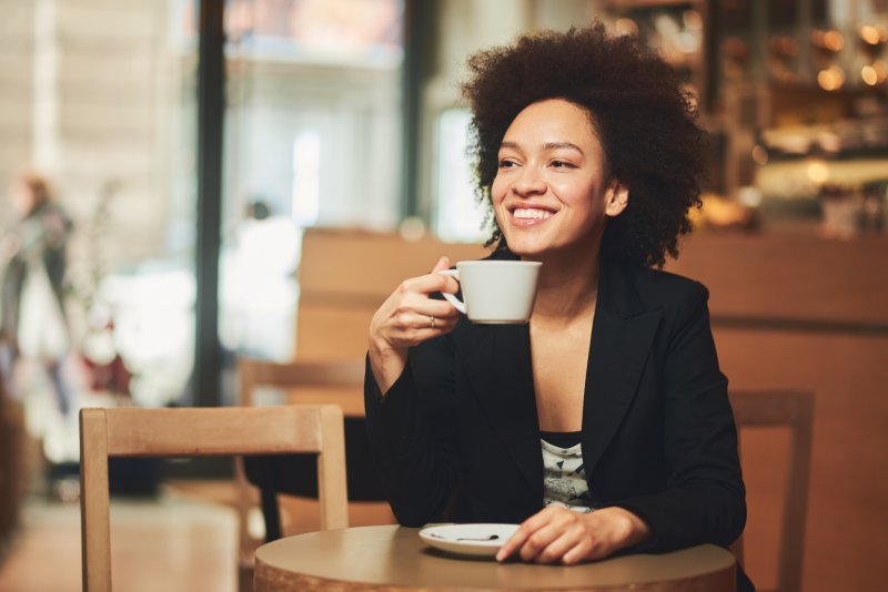 woman drinking coffee with veneers in Spring Hill