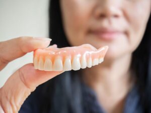 Close-up of woman holding her upper denture