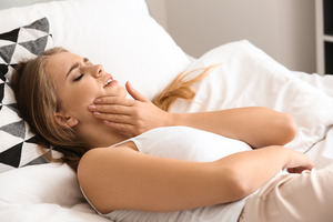 Woman lying in bed with a toothache